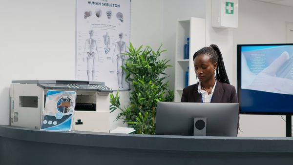 A women working in a medical clinic behind a reception table